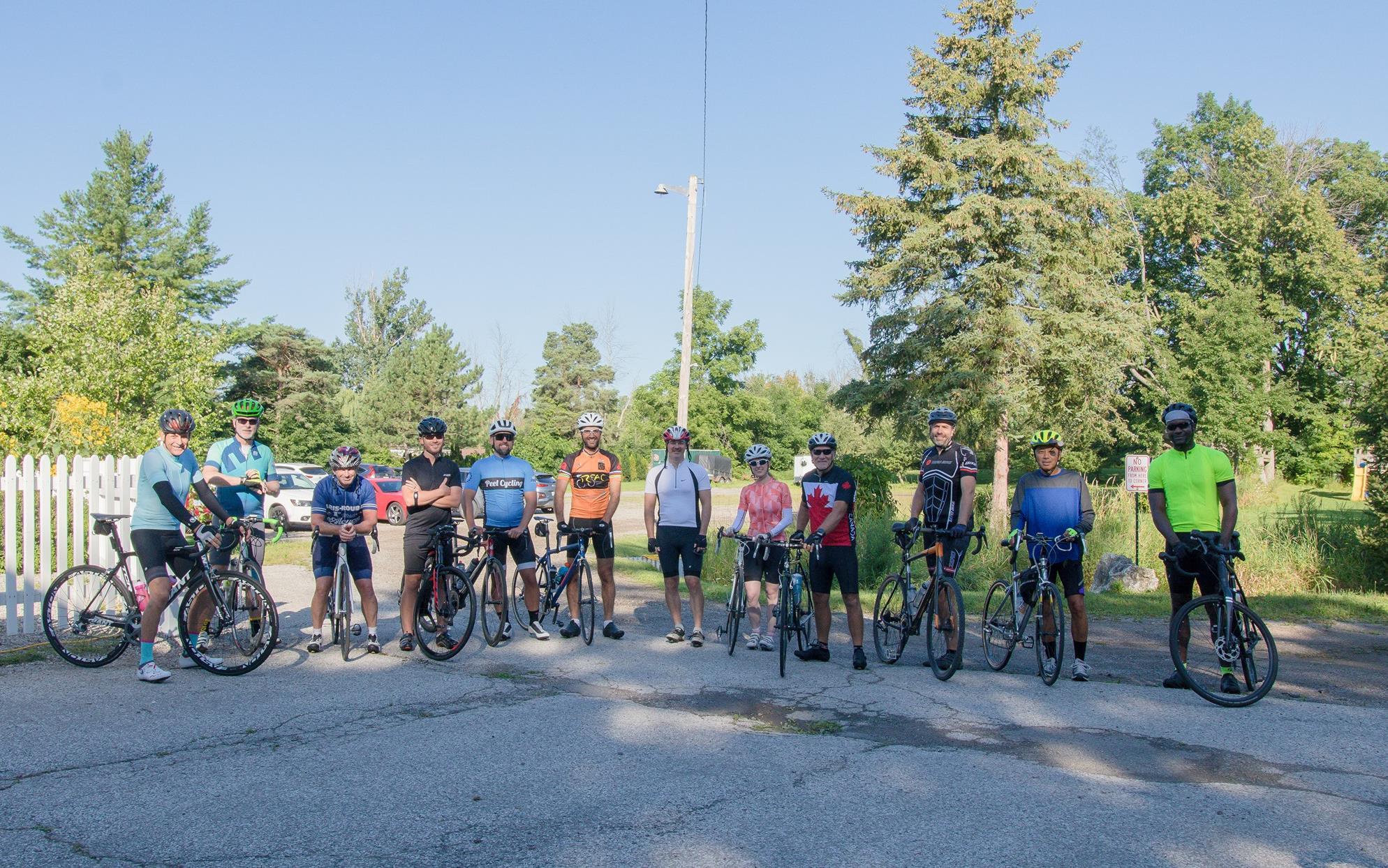 Photo of Murray Cornelius surrounded by 11 colleagues (and their bikes) riding in the Toronto ride to thrive.