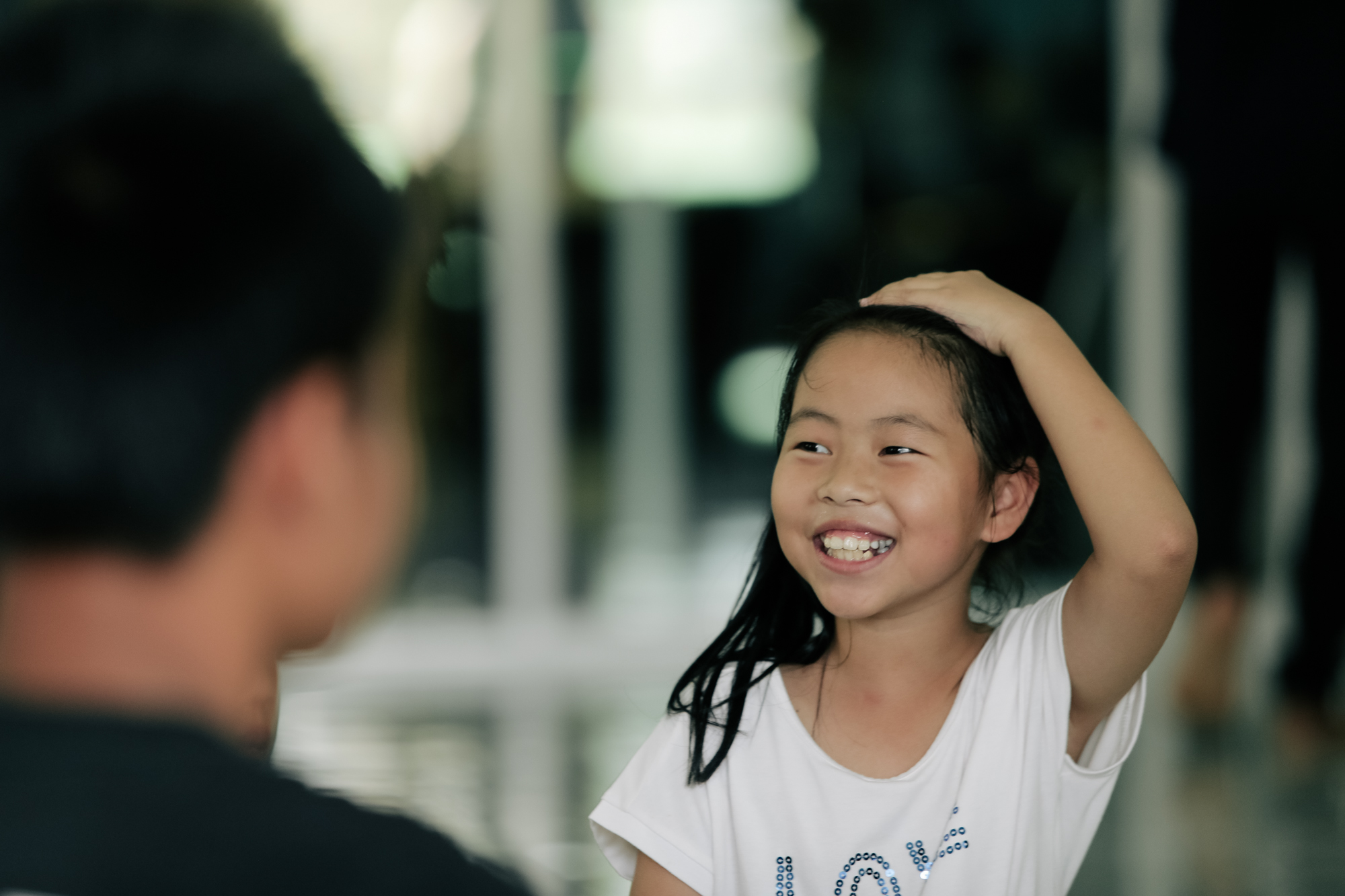 Photo of a little girl smiling while talking to other students from Imagine Thailand