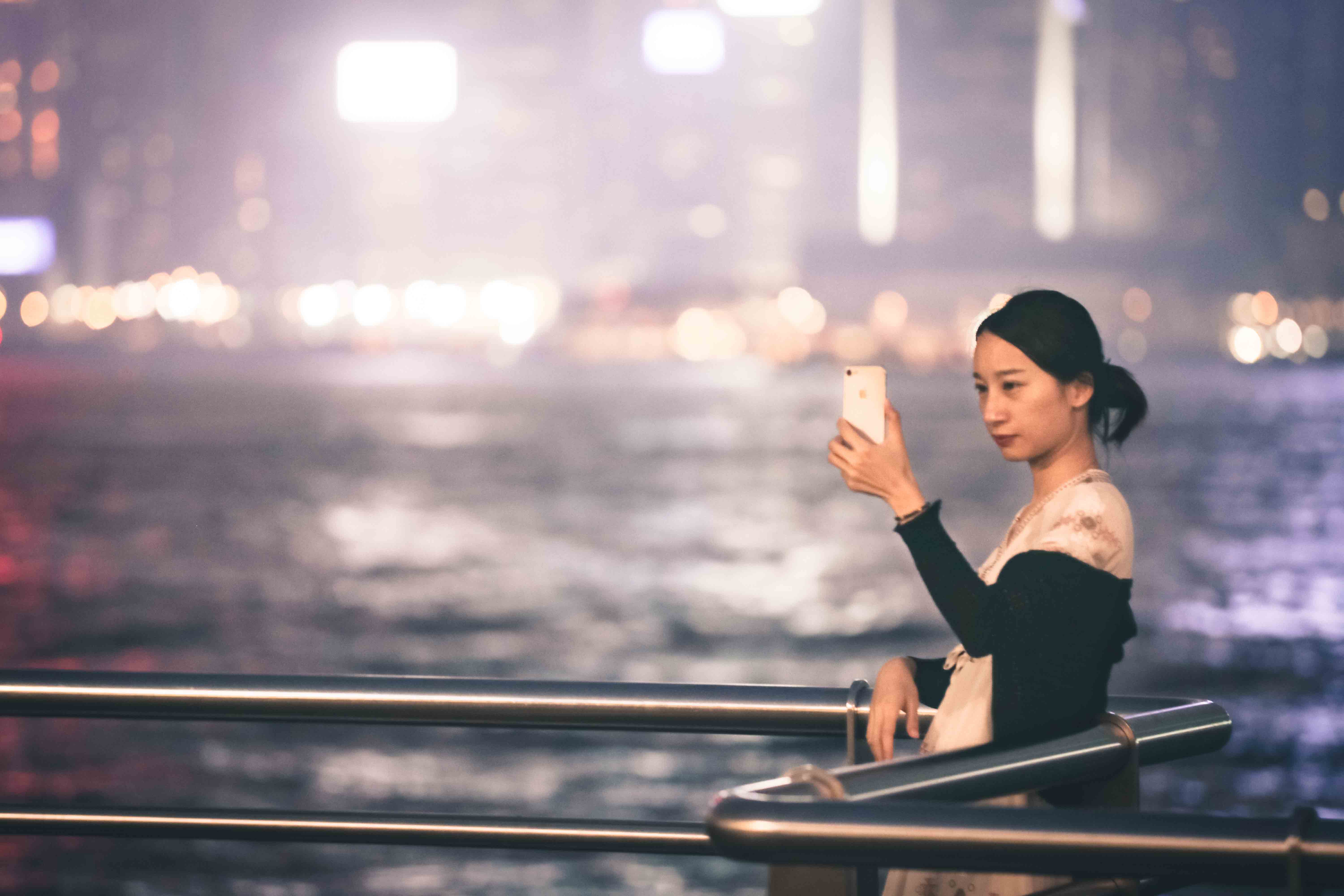 Photo of a lady taking a picture in Hong Kong.