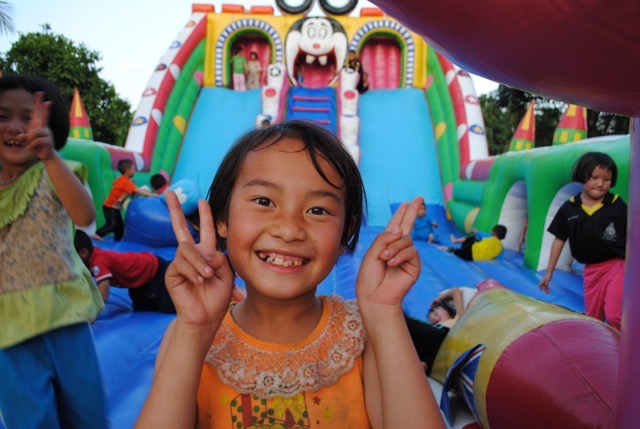 Girl smiling at bottom of a slide in Cambodia