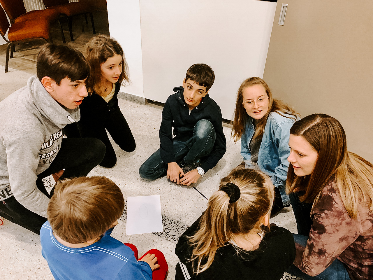 Photo of a group of students working in a circle.