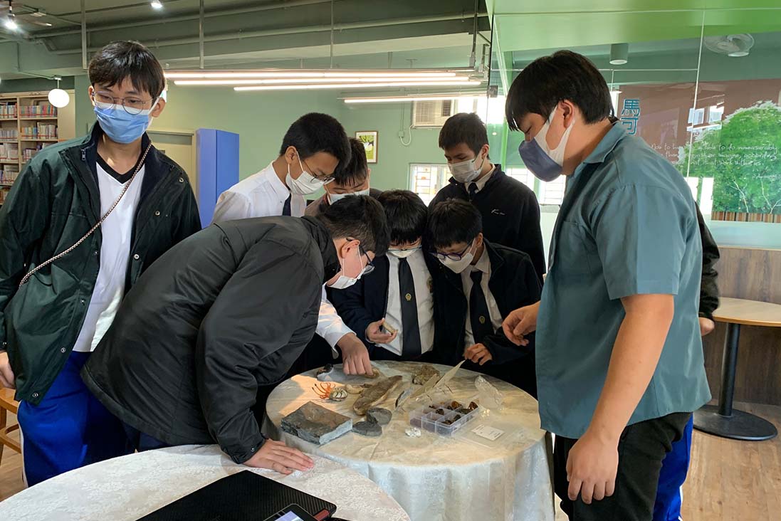 Photo of a group of students working on a project together at school from Ka Chi Secondary School.