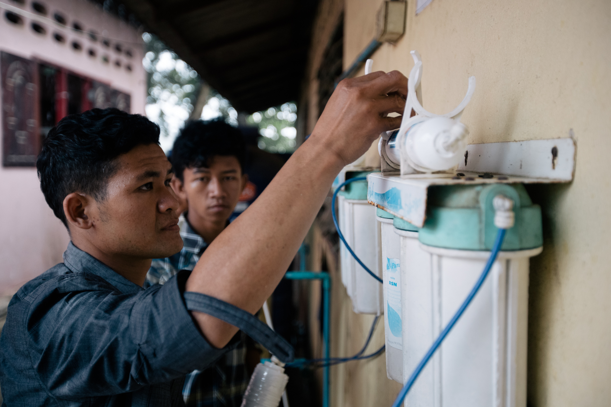 Photo of two young adults fixing a water filter by Imagine Thailand