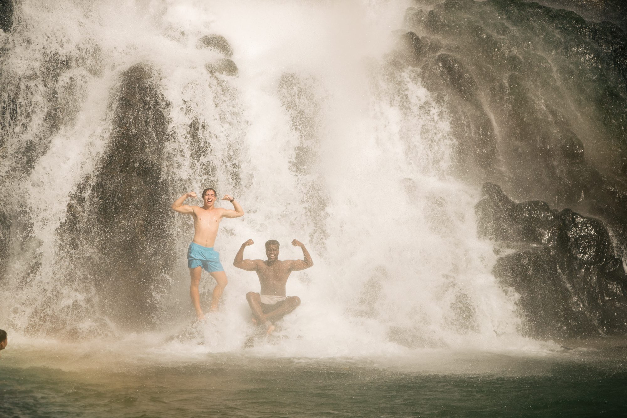 Photo of two boys jumping from a waterfall by Imagine Thailand