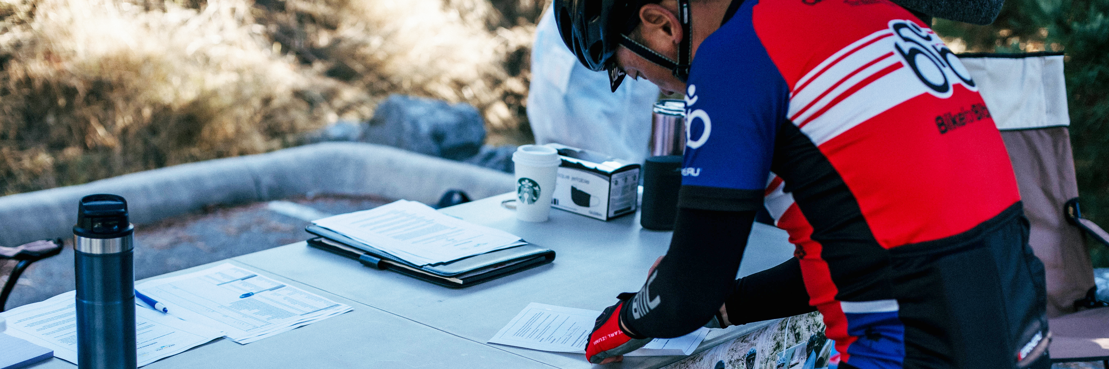 Photo banner for the 2022 Ride to Thrive with a photo of a someone signing a waiver 2021 event in Abbotsford, BC