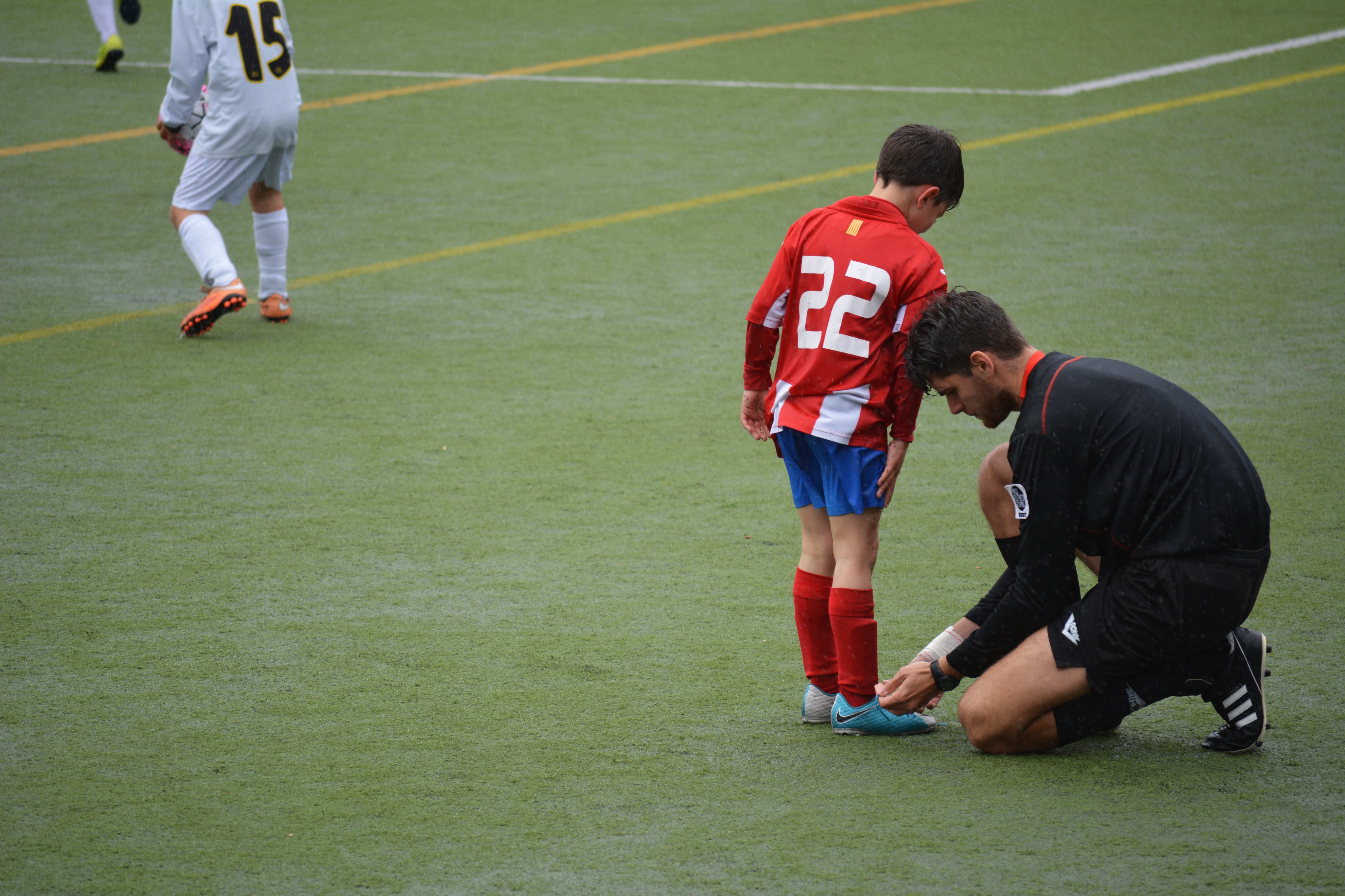Photo of a soccer coach helping a team member by Adria Crehuet on Unsplash