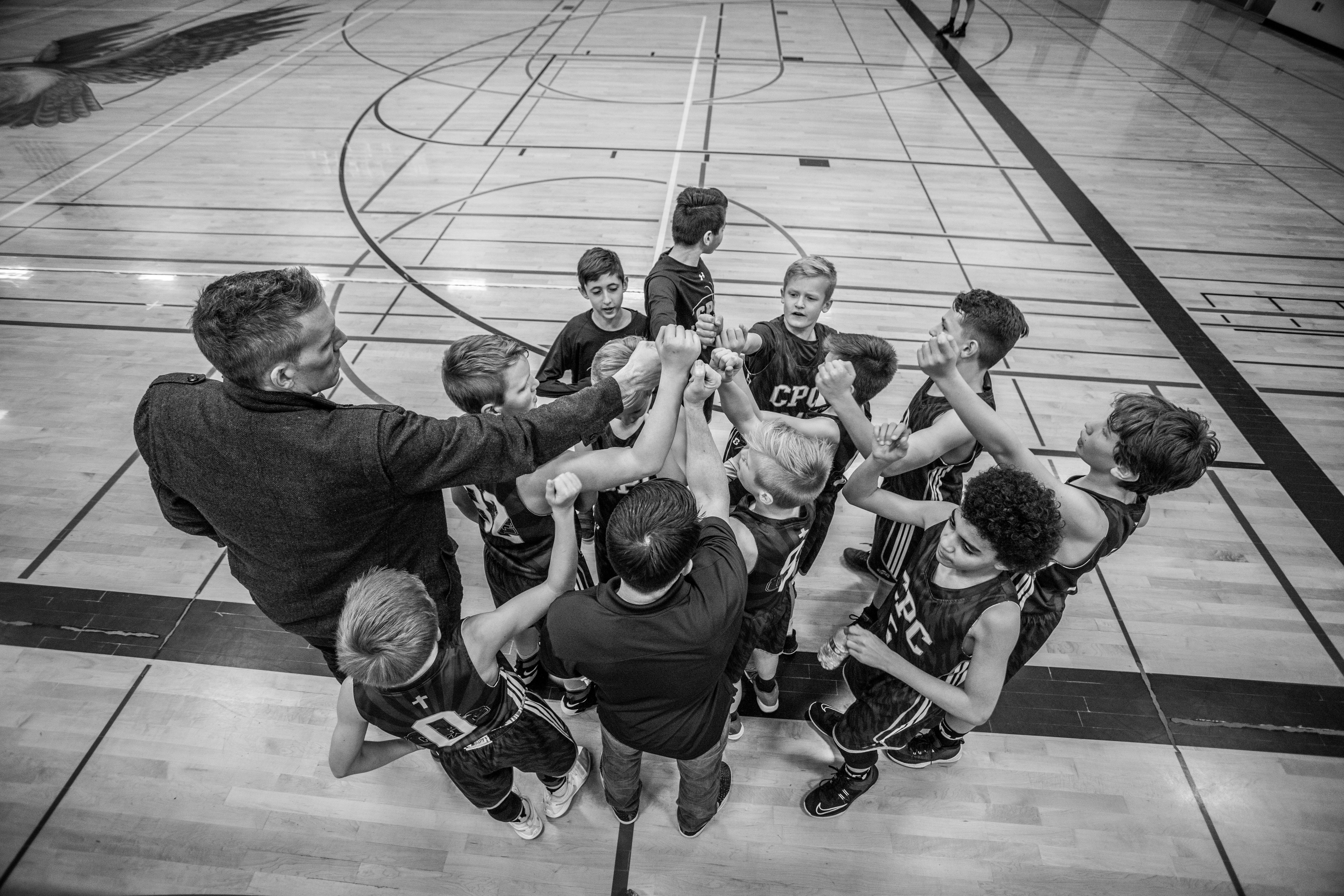 Photo of a team in a group huddle by Jesse Orrico on Unsplash