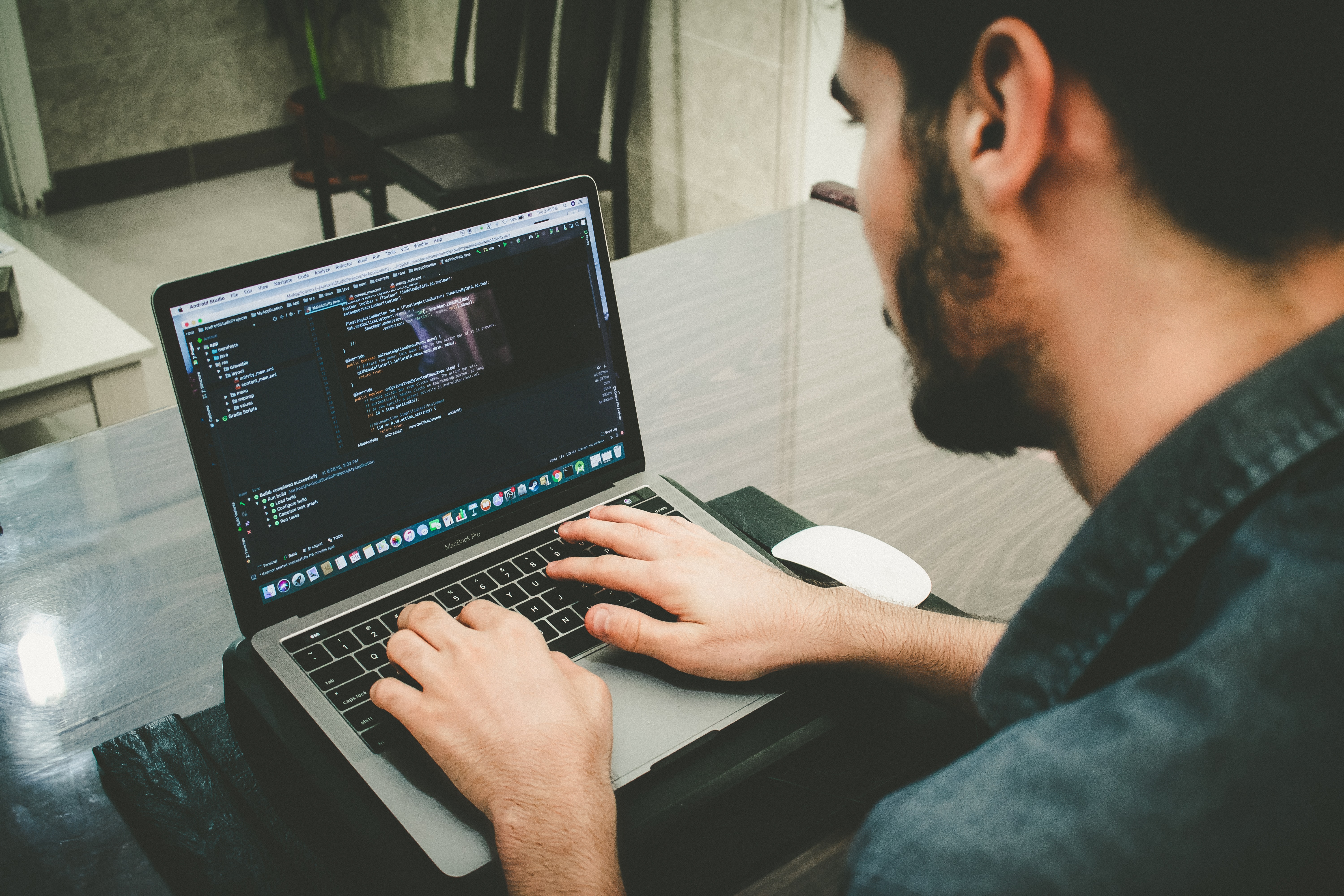 Photo of someone working on a code on a computer by Daniel Igdery on Unsplash