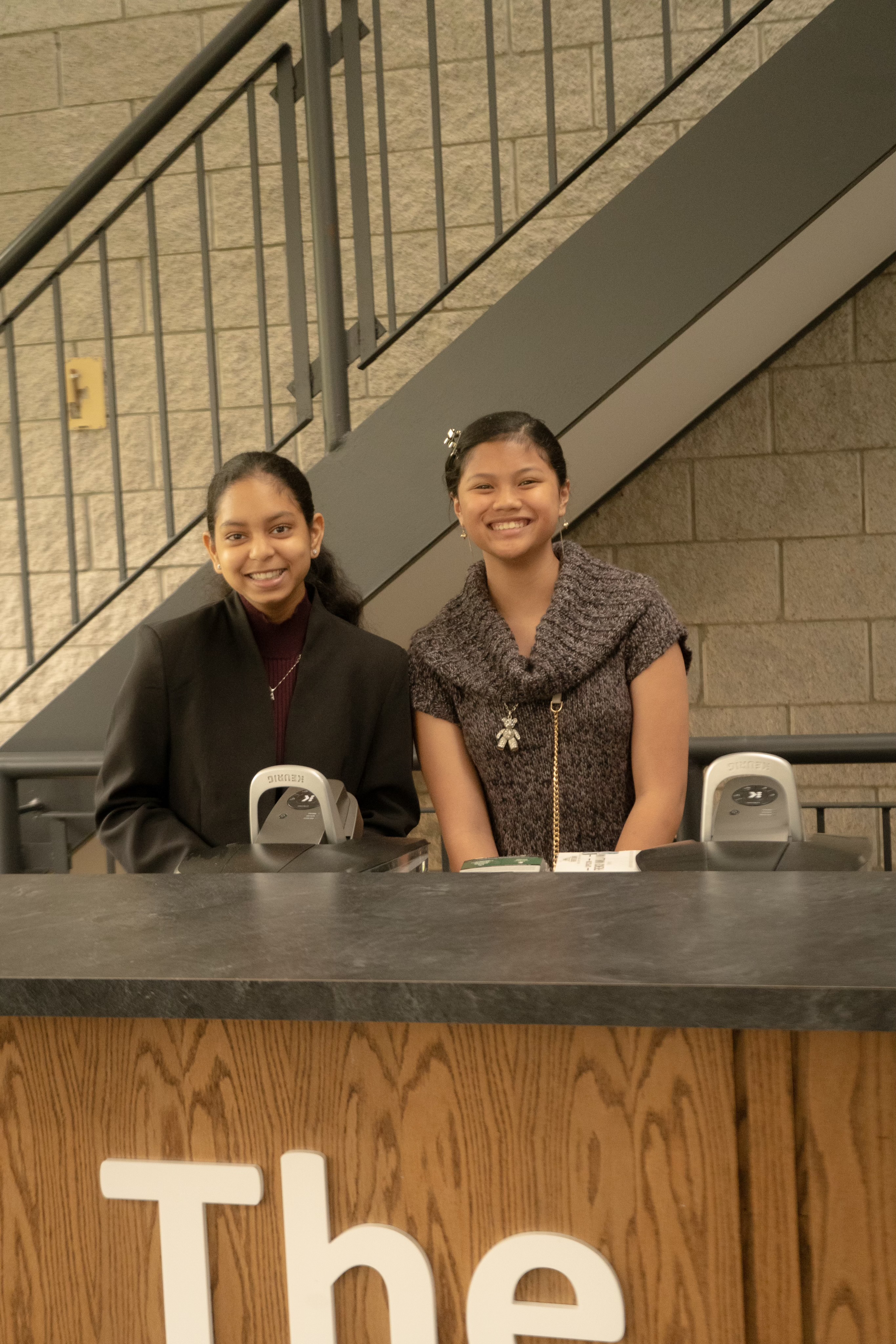 Two girls standing at a counter.