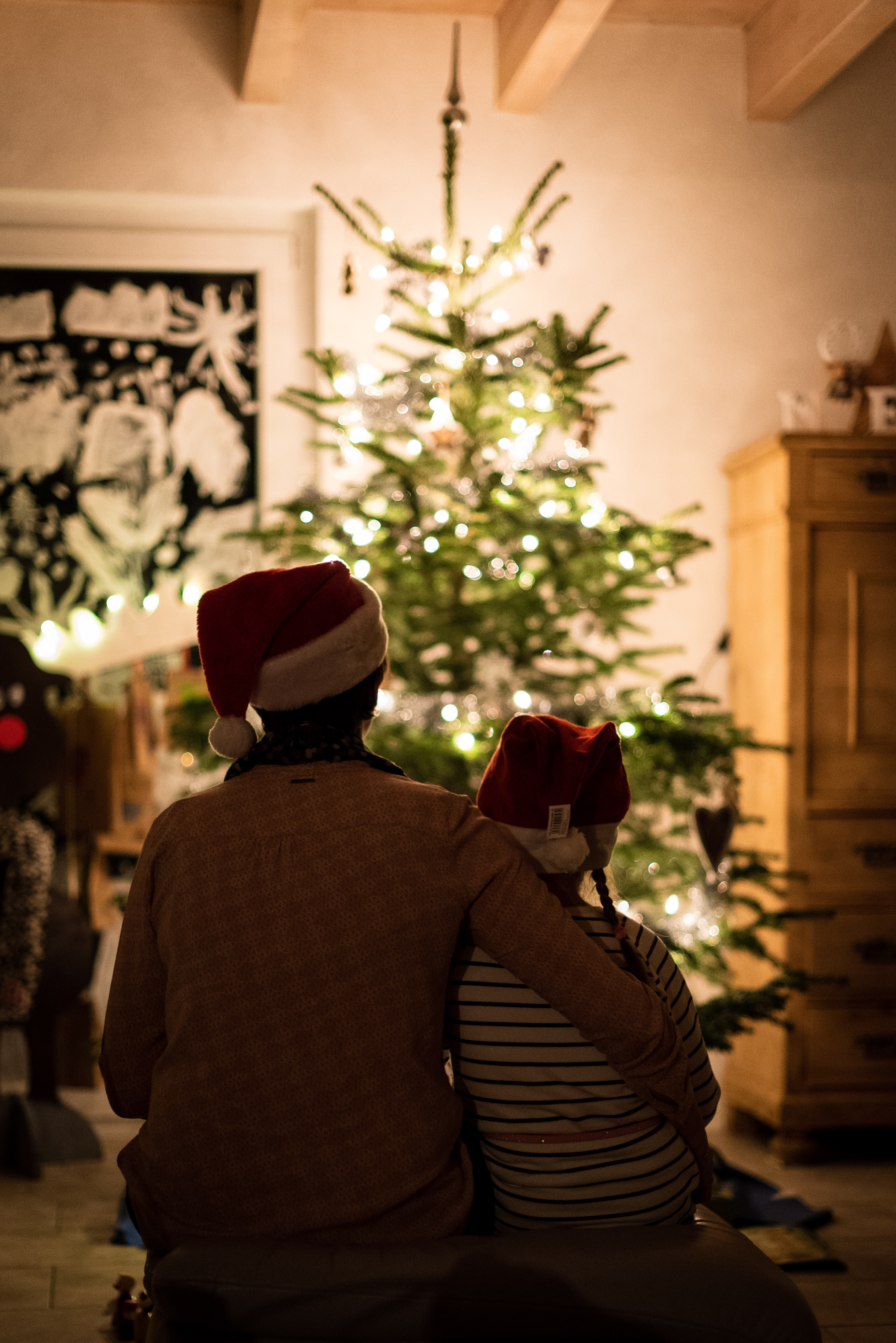 People sitting in front of a Christmas tree.