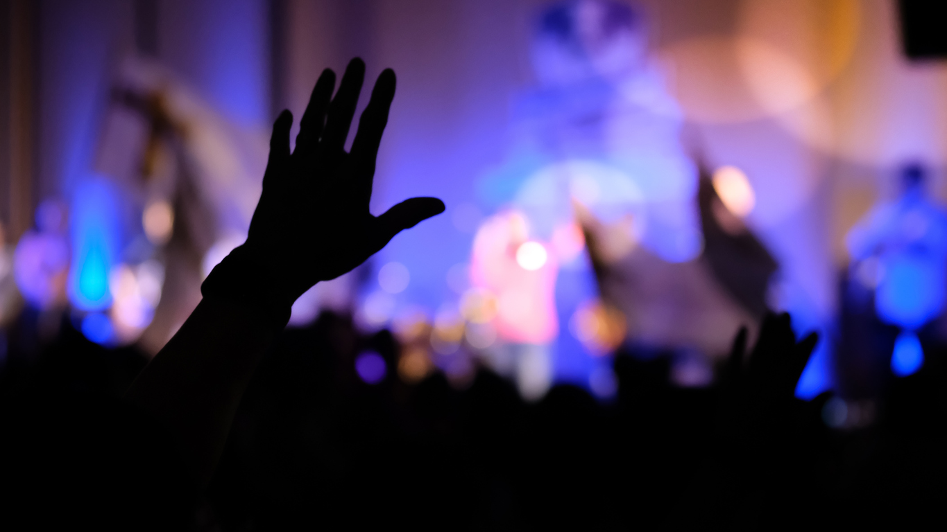 Person raising their hand in worship.