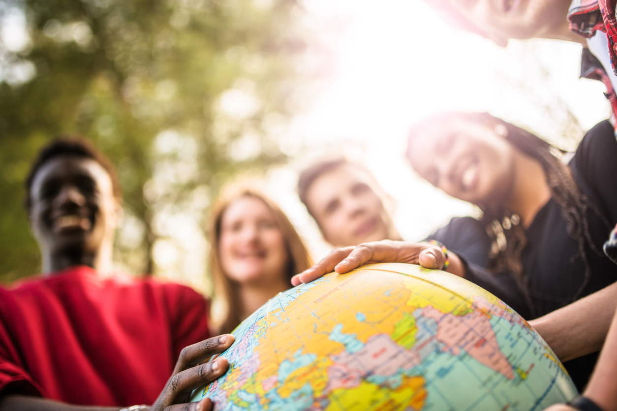 People with their hands on a globe.