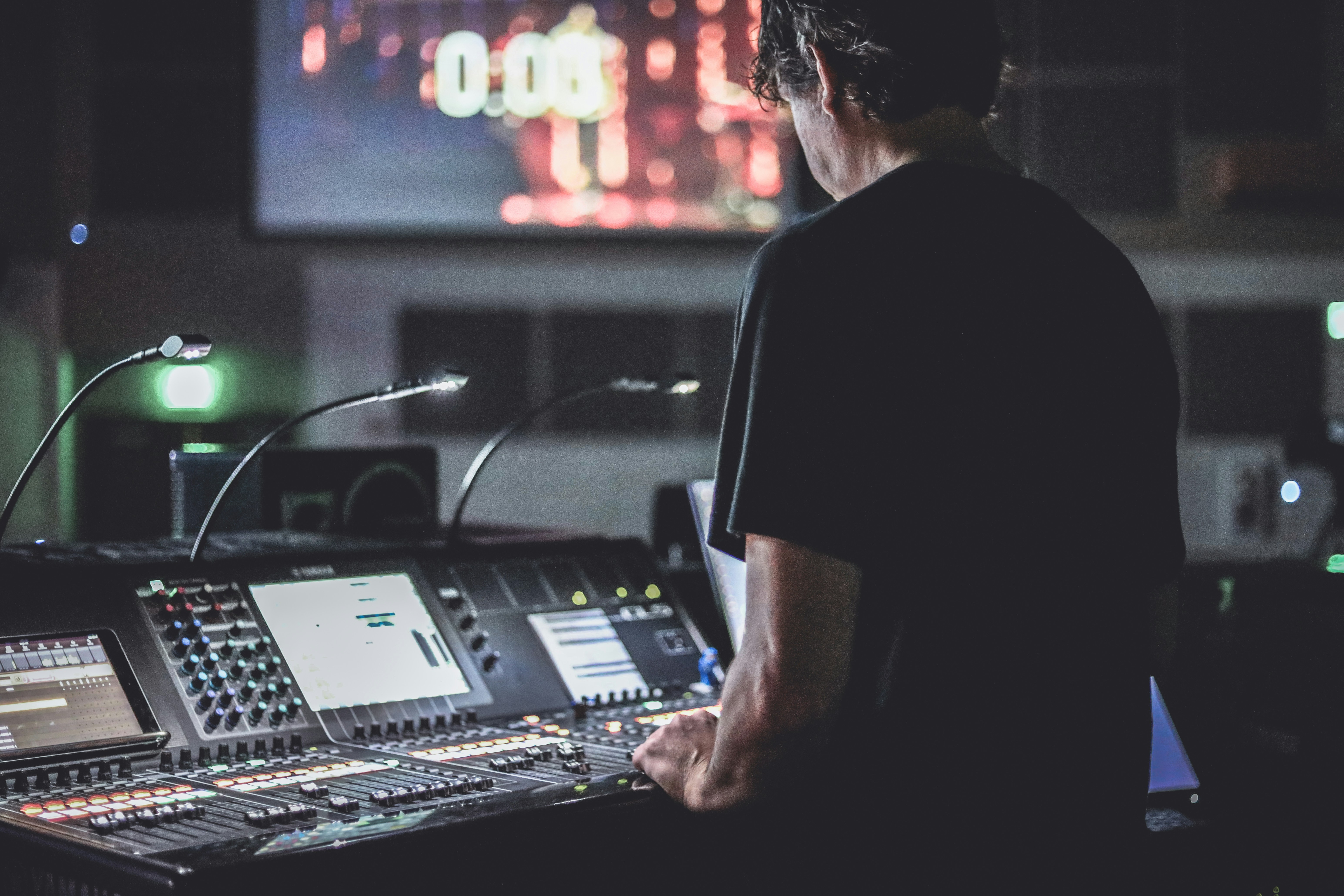 Photo of a man standing in front of a soundboard.