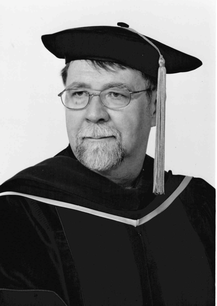 Photo of Roger Stronstad in a graduation cap and gown.