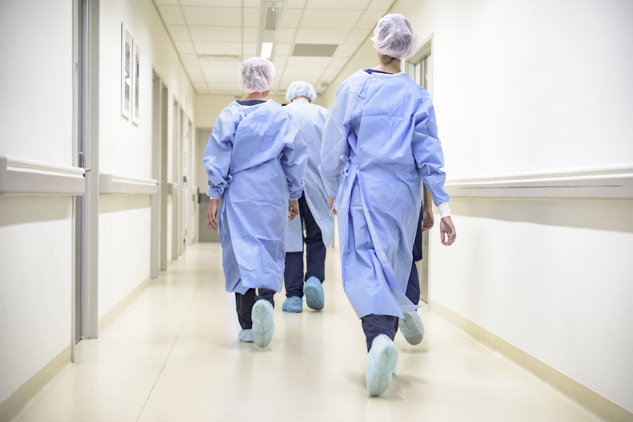 Photo of people in a hospital walking down a hallway.