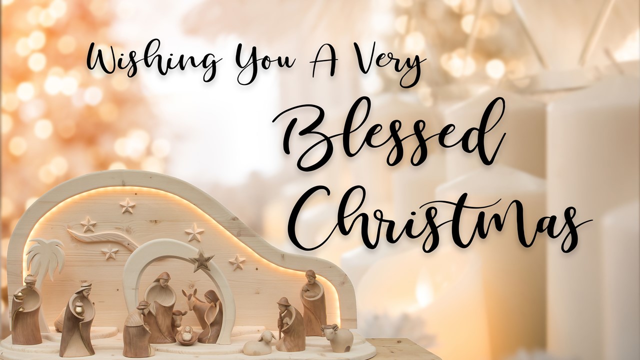 Stock image of a Nativity scene made of wooden figures, with the words "Wishing You A Very Blessed Christmas" displayed