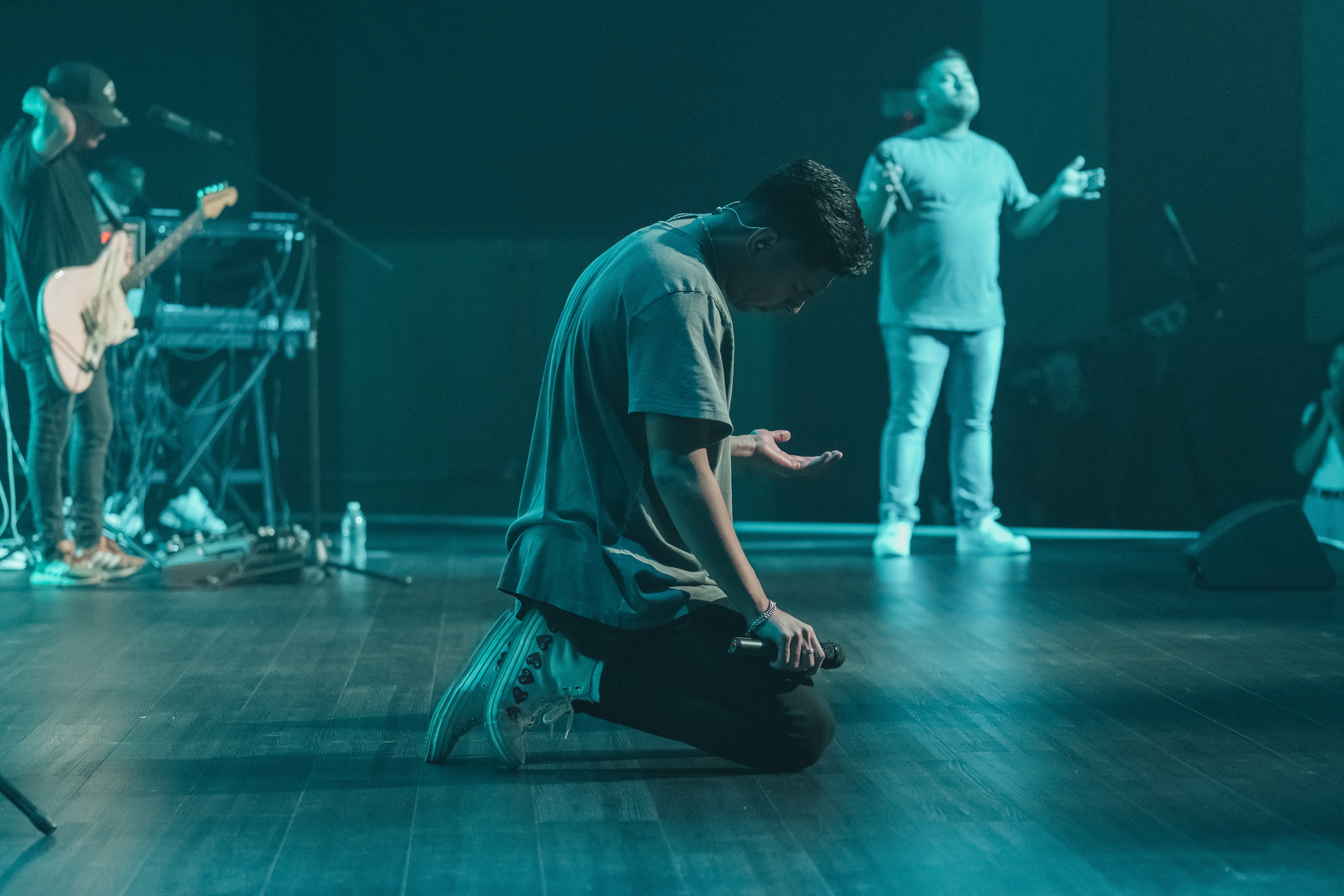 Worship leader on knees on stage.
